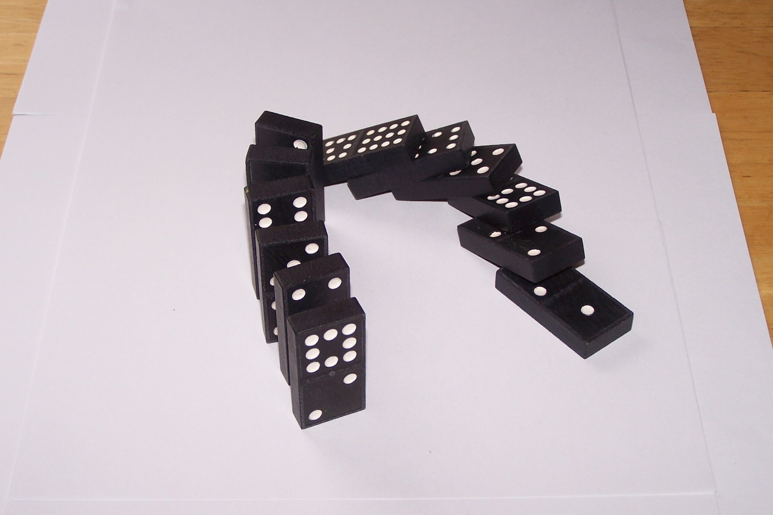 12 dominoes falling over in a curve.